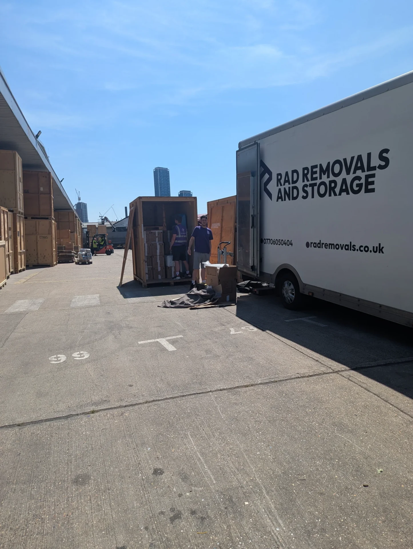 RAD Removals van parked at a London storage facility with visible wooden storage pods and containers